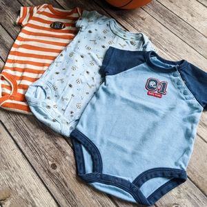 Newborn boy sports themed Onesies